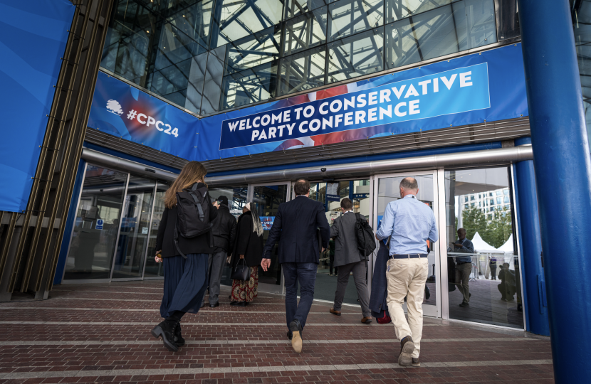 People Walking into the ICC with a Welcome to Conference Sign above the doors